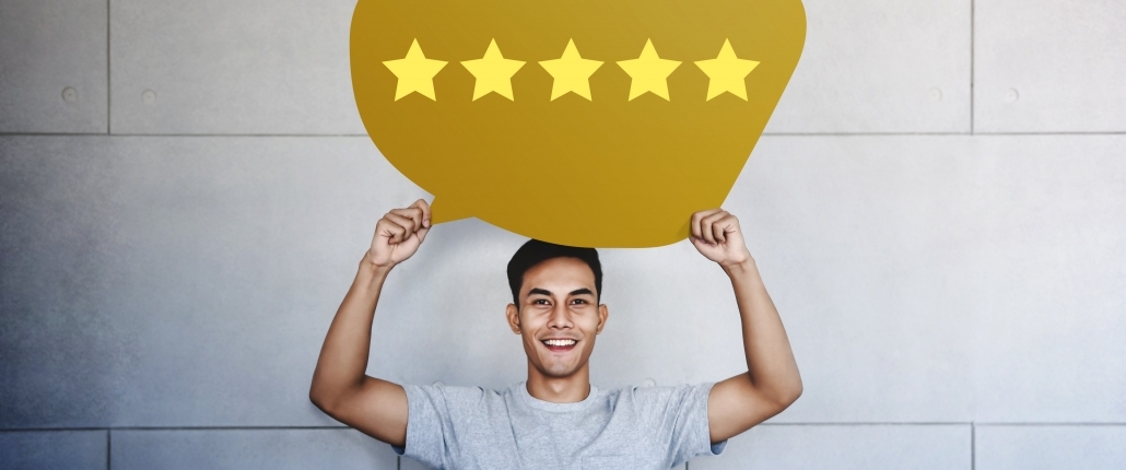 ustomer Experience Concept. Young Man with Happy Face Showing Five Star Services Rating Satisfaction on Speech Bubble Card. Happy Client's Feedback and Online Review